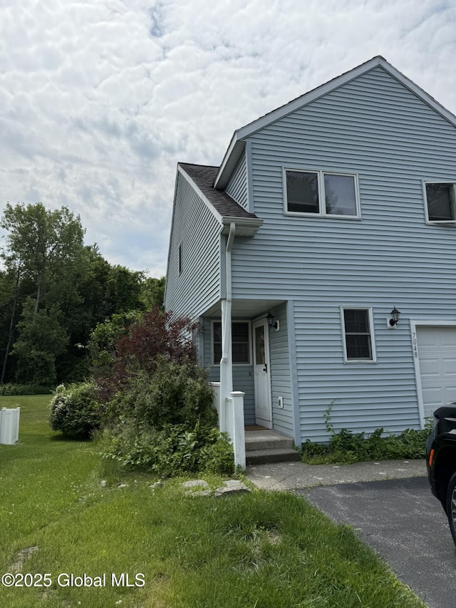 7048 Suzanne Ln, Guilderland, NY 12303 - view of front facade featuring a front yard, an attached garage, and asphalt driveway