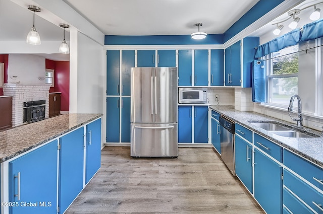 134 Whitehall Rd, Albany, NY 12209 - kitchen with appliances with stainless steel finishes, blue cabinets, tasteful backsplash, light wood-style floors, and light stone counters