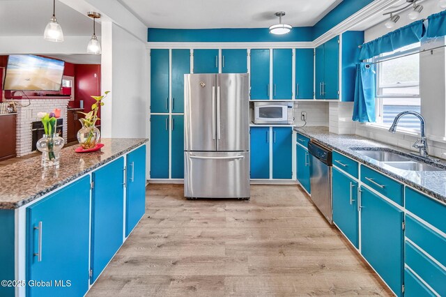 134 Whitehall Rd, Albany, NY 12209 - kitchen with appliances with stainless steel finishes, blue cabinets, backsplash, light wood-style floors, and stone countertops