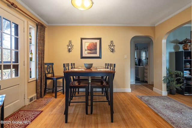 2305 Balltown Rd, Niskayuna, NY 12309 - dining space featuring arched walkways, ornamental molding, and light wood-style flooring