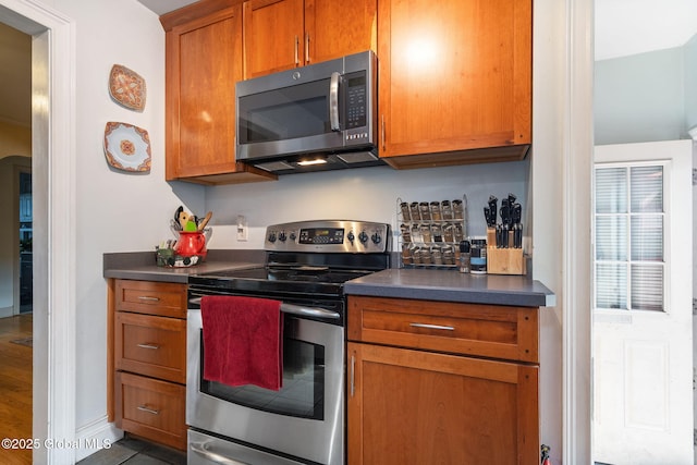 2305 Balltown Rd, Niskayuna, NY 12309 - kitchen featuring stainless steel electric stove, dark countertops, brown cabinetry, and arched walkways