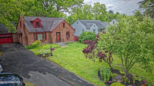 2305 Balltown Rd, Niskayuna, NY 12309 - view of front of house featuring brick siding, a front lawn, a garage, a chimney, and view of wooded area