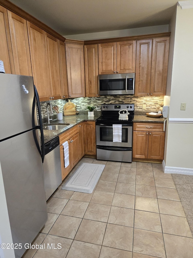 8 Wall St Unit 236, Clifton Park, NY 12065 - kitchen featuring stainless steel appliances, decorative backsplash, dark stone counters, light tile patterned flooring, and brown cabinets