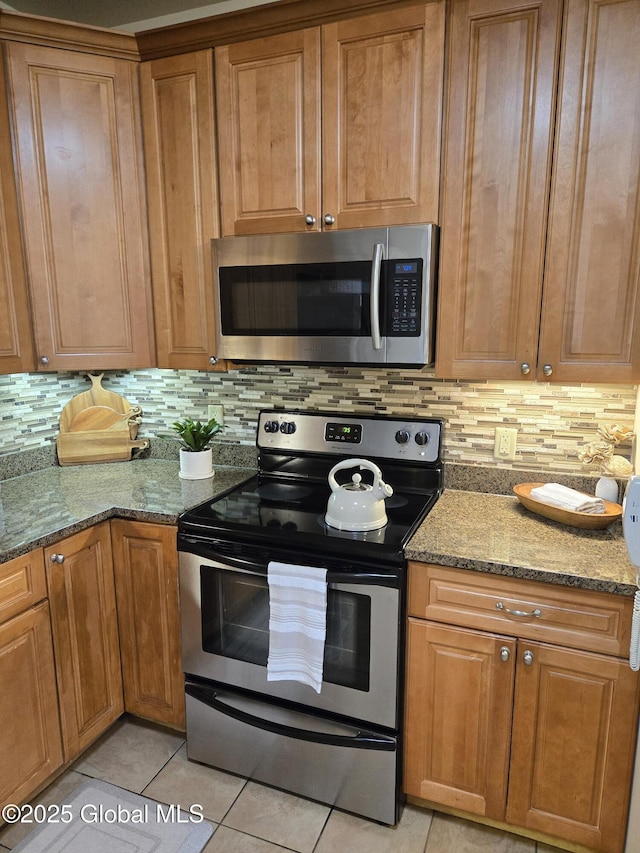 8 Wall St Unit 236, Clifton Park, NY 12065 - kitchen featuring appliances with stainless steel finishes, light tile patterned flooring, backsplash, and stone counters