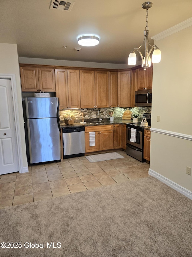 8 Wall St Unit 236, Clifton Park, NY 12065 - kitchen featuring stainless steel appliances, light tile patterned flooring, tasteful backsplash, brown cabinetry, and ornamental molding
