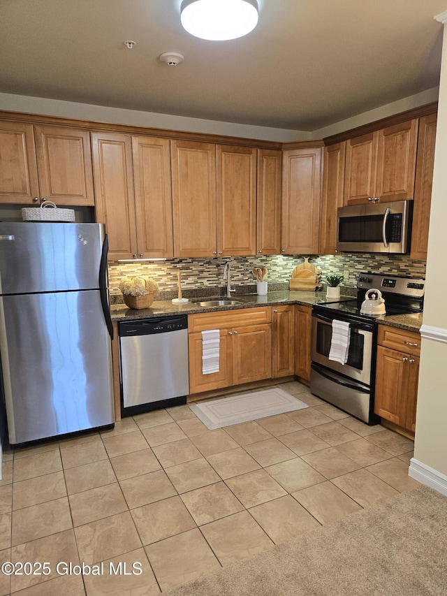 8 Wall St Unit 236, Clifton Park, NY 12065 - kitchen with appliances with stainless steel finishes, tasteful backsplash, light tile patterned floors, and brown cabinetry
