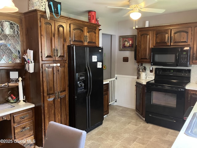 185 Butler St, Schenectady, NY 12303 - kitchen featuring black appliances, light countertops, ceiling fan, and a wainscoted wall