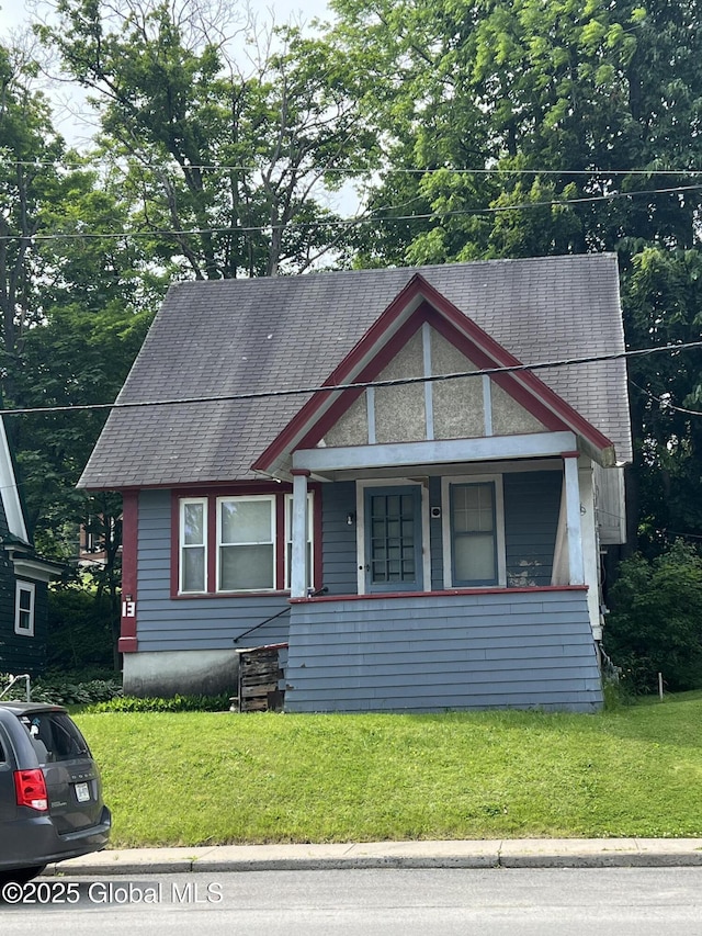 13 Wheeler, Canajoharie Village, NY 13317 - view of front facade featuring covered porch, a front yard, and a shingled roof