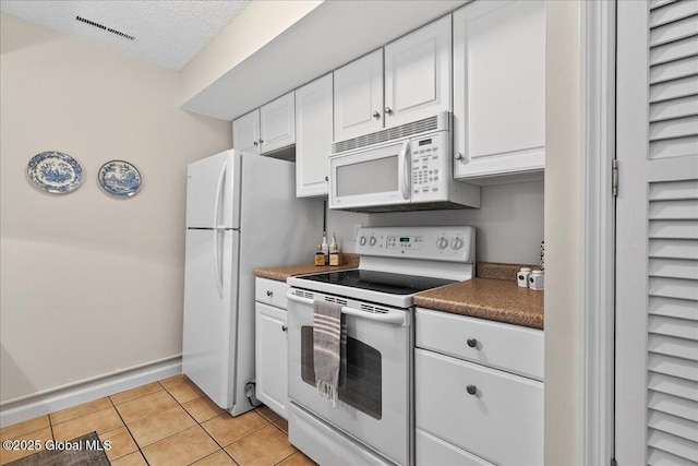 16 Whispering Pines Rd, Wilton, NY 12831 - kitchen featuring white appliances, white cabinets, light tile patterned floors, dark countertops, and a textured ceiling