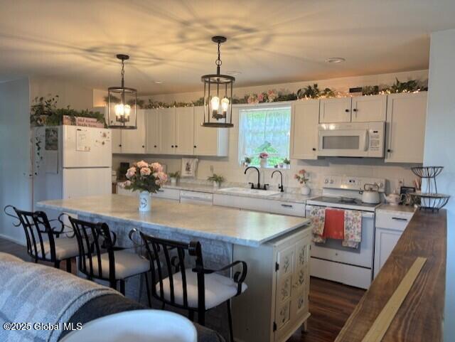 600 State Highway 309, Gloversville, NY 12078 - kitchen with white appliances, a kitchen breakfast bar, white cabinets, light countertops, and hanging light fixtures