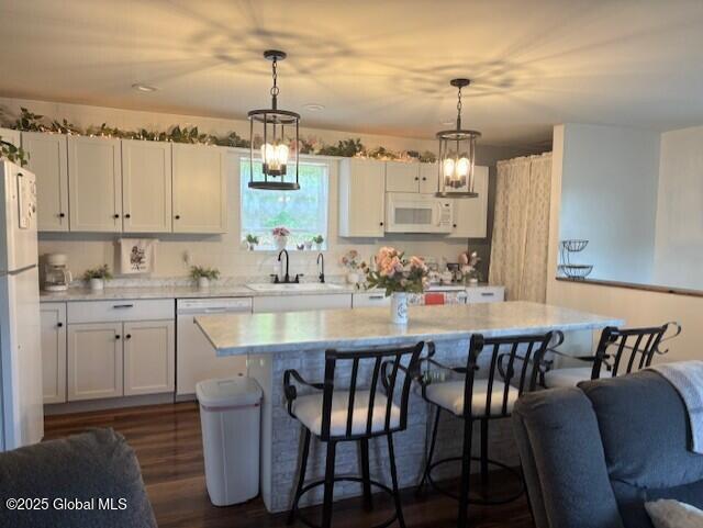 600 State Highway 309, Gloversville, NY 12078 - kitchen with white appliances, a kitchen breakfast bar, light countertops, a kitchen island, and white cabinetry