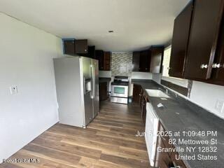 82 Mettowee St, Granville, NY 12832 - kitchen with stainless steel fridge, white range, dark brown cabinetry, wood finished floors, and dark countertops