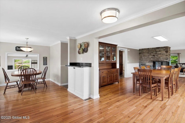 344 Fortsville Rd, Moreau, NY 12831 - dining room featuring light wood-style flooring, ornamental molding, and a stone fireplace