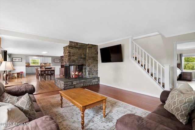 344 Fortsville Rd, Moreau, NY 12831 - living area featuring light wood-type flooring, stairway, a stone fireplace, and ornamental molding