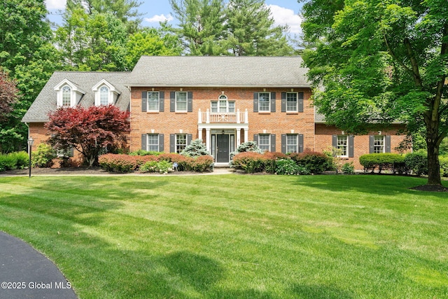 428 Ridgehill Rd, Guilderland, NY 12303 - colonial-style house featuring a balcony, a front yard, and brick siding