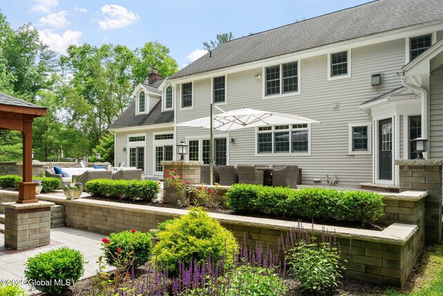 428 Ridgehill Rd, Guilderland, NY 12303 - rear view of house featuring an outdoor living space, a patio, and a chimney
