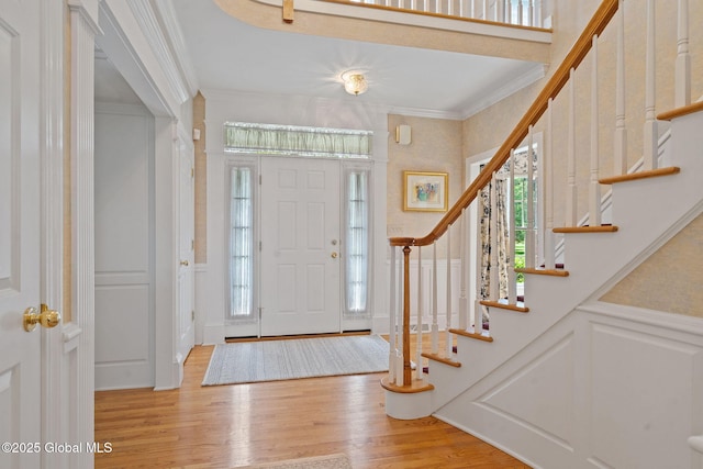 428 Ridgehill Rd, Guilderland, NY 12303 - foyer entrance with a decorative wall, stairs, wood finished floors, ornamental molding, and a wainscoted wall
