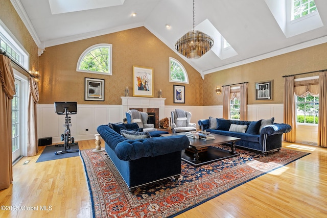 428 Ridgehill Rd, Guilderland, NY 12303 - living room featuring a skylight, plenty of natural light, wainscoting, wood finished floors, and a tile fireplace