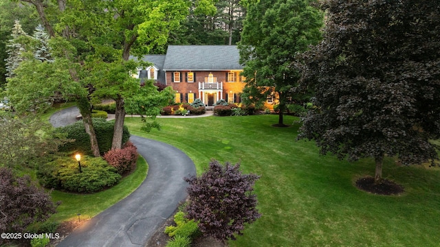 428 Ridgehill Rd, Guilderland, NY 12303 - georgian-style home featuring curved driveway, a balcony, a front yard, and brick siding