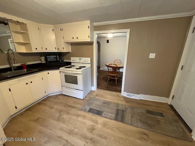 27 Emery Ave, Colonie, NY 12205 - kitchen with electric stove, open shelves, light wood finished floors, dark countertops, and crown molding