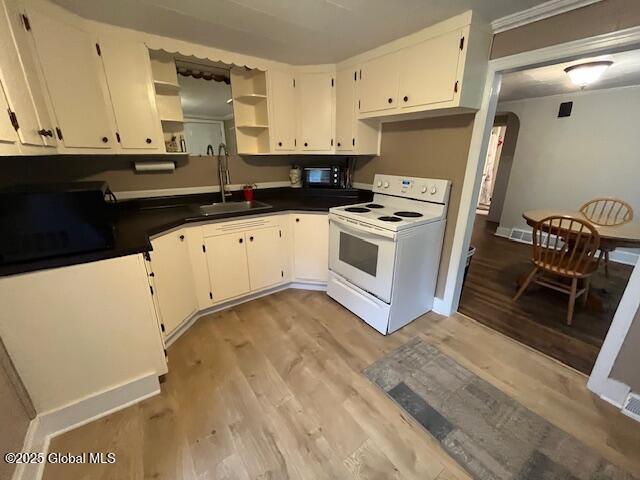 27 Emery Ave, Colonie, NY 12205 - kitchen featuring white range with electric stovetop, open shelves, light wood-style flooring, dark countertops, and white cabinetry