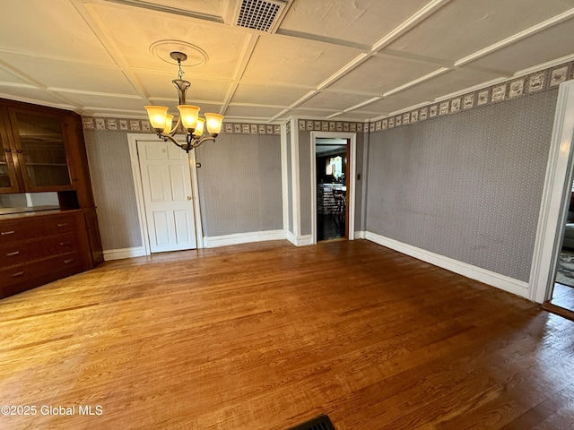 252 Main St, Hudson Falls, NY 12839 - unfurnished dining area featuring a chandelier, wood finished floors, wallpapered walls, and an ornate ceiling