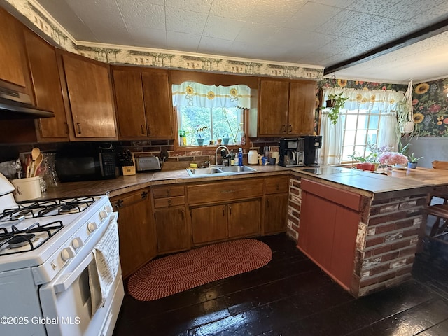 252 Main St, Hudson Falls, NY 12839 - kitchen with white gas range oven, plenty of natural light, and brown cabinets