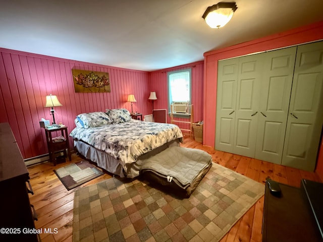 252 Main St, Hudson Falls, NY 12839 - bedroom featuring light wood-style flooring, cooling unit, a closet, and a baseboard heating unit