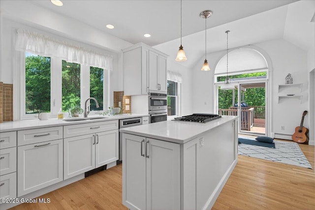 460 Grand Ave, Saratoga Springs, NY 12866 - kitchen featuring appliances with stainless steel finishes, healthy amount of natural light, light wood-style flooring, white cabinets, and lofted ceiling