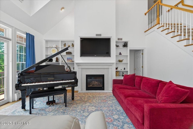 460 Grand Ave, Saratoga Springs, NY 12866 - living area with high vaulted ceiling, built in features, stairway, and a glass covered fireplace