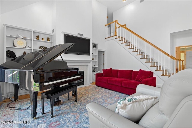 460 Grand Ave, Saratoga Springs, NY 12866 - living area featuring a towering ceiling, stairs, and a fireplace with flush hearth