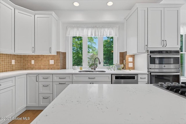 460 Grand Ave, Saratoga Springs, NY 12866 - kitchen with stainless steel appliances, white cabinetry, light stone countertops, tasteful backsplash, and recessed lighting