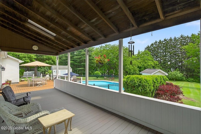 479 Loudon Rd, Colonie, NY 12211 - wooden terrace featuring outdoor dining area, an outdoor pool, a shed, and view of wooded area