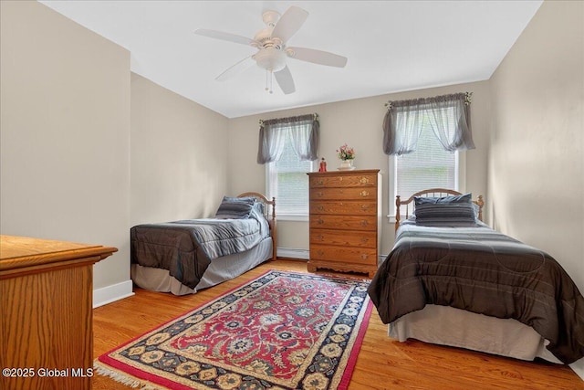 479 Loudon Rd, Colonie, NY 12211 - bedroom with wood finished floors, a baseboard heating unit, and ceiling fan