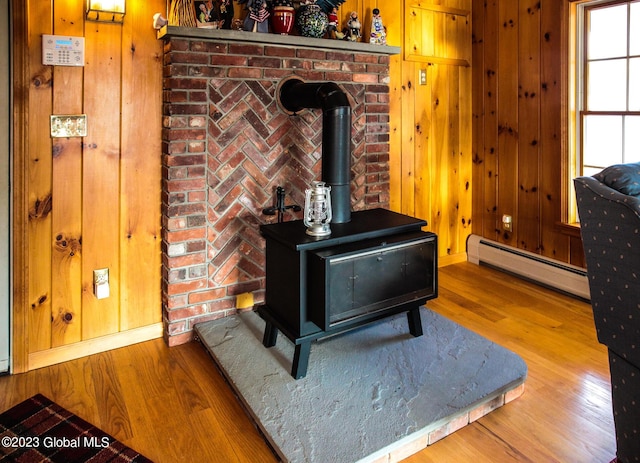 42 Stanton Rd, Jackson, NY 12873 - detailed view of a wood stove, a baseboard radiator, wood finished floors, and wooden walls