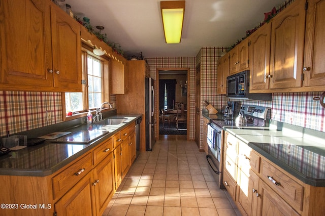 42 Stanton Rd, Jackson, NY 12873 - kitchen with stainless steel appliances, wallpapered walls, light tile patterned flooring, brown cabinets, and dark countertops