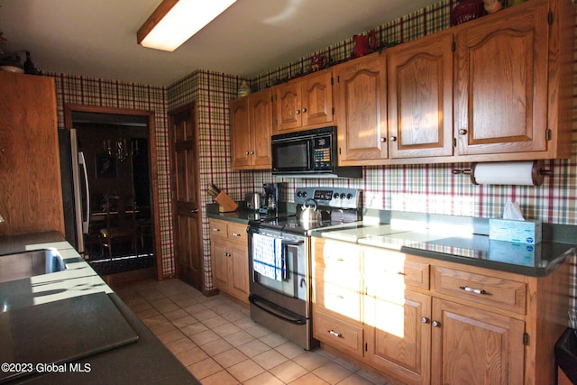 42 Stanton Rd, Jackson, NY 12873 - kitchen with stainless steel electric range oven, wallpapered walls, black microwave, light tile patterned floors, and dark countertops