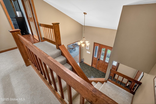 1560 Division St, Charlton, NY 12010 - staircase featuring high vaulted ceiling, carpet floors, and a chandelier