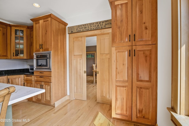 555 Trout Lake Rd, Bolton, NY 12824 - kitchen featuring light wood finished floors, dark stone countertops, tasteful backsplash, glass insert cabinets, and recessed lighting