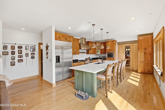 555 Trout Lake Rd, Bolton, NY 12824 - kitchen featuring stainless steel built in fridge, wall chimney exhaust hood, light wood-style flooring, a center island with sink, and a kitchen breakfast bar