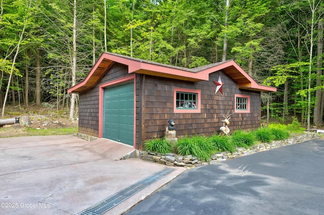 555 Trout Lake Rd, Bolton, NY 12824 - detached garage featuring a view of trees and concrete driveway