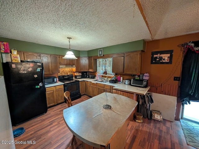 312 Ridge Rd, Northampton, NY 12134 - kitchen featuring black appliances, wood finished floors, light countertops, healthy amount of natural light, and a textured ceiling