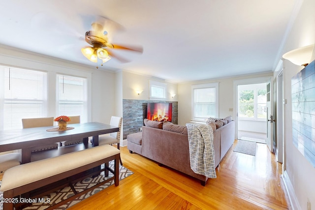 66 Roosevelt Ave, Schenectady, NY 12304 - living room featuring light wood-style flooring, ceiling fan, ornamental molding, and a stone fireplace