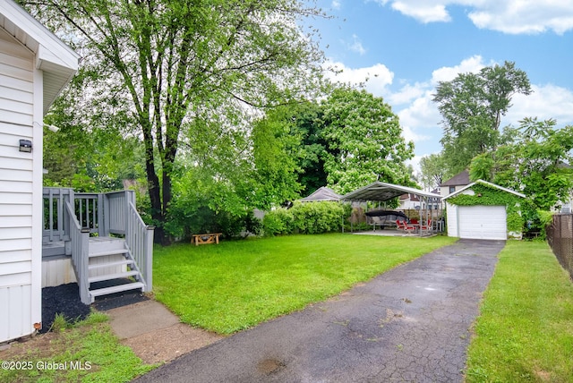66 Roosevelt Ave, Schenectady, NY 12304 - view of grassy yard with a carport, asphalt driveway, a garage, and an outbuilding
