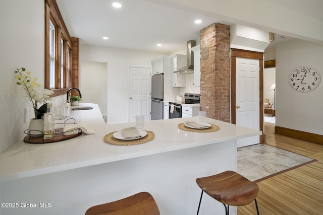 11 River St, Stamford, NY 12167 - kitchen featuring stainless steel appliances, wall chimney exhaust hood, a breakfast bar, a peninsula, and recessed lighting