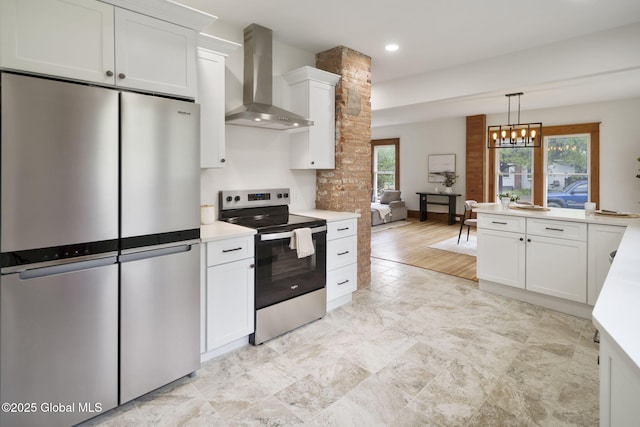 11 River St, Stamford, NY 12167 - kitchen featuring stainless steel appliances, wall chimney exhaust hood, light countertops, white cabinets, and hanging light fixtures