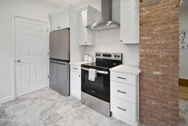11 River St, Stamford, NY 12167 - kitchen featuring wall chimney exhaust hood, appliances with stainless steel finishes, light countertops, brick wall, and white cabinetry
