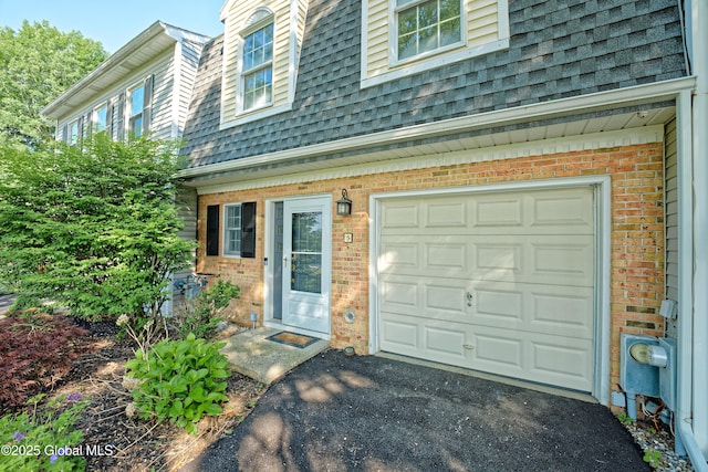 5 Bridgewood Ln, Watervliet, NY 12189 - doorway to property featuring roof with shingles, brick siding, asphalt driveway, and a garage