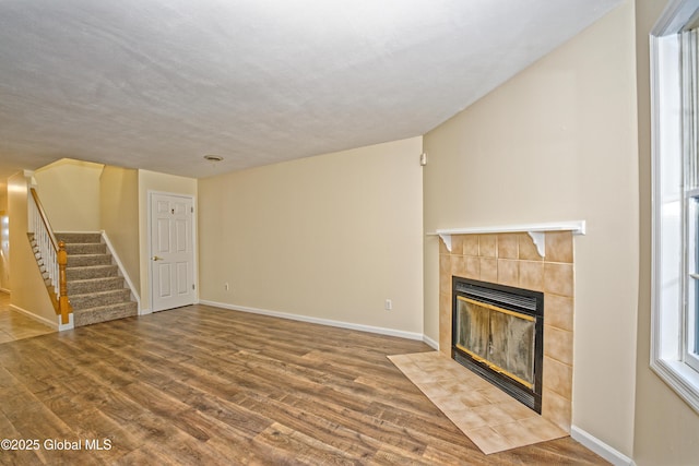 5 Bridgewood Ln, Watervliet, NY 12189 - unfurnished living room with a tiled fireplace, wood finished floors, and stairs