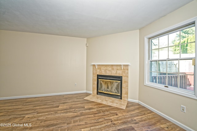 5 Bridgewood Ln, Watervliet, NY 12189 - unfurnished living room featuring a tiled fireplace and wood finished floors